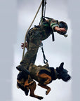 U.S. Marine and military working dog tandem on a SPIE line under a helicopter, showing the SPIE system's ability to safely extract both personnel and animals. (8745383624941)