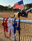 Ravenox red, white, and blue twisted cotton horse leads with chain and snap, displayed at a horse rodeo with an American flag in the background. (1806013268058)